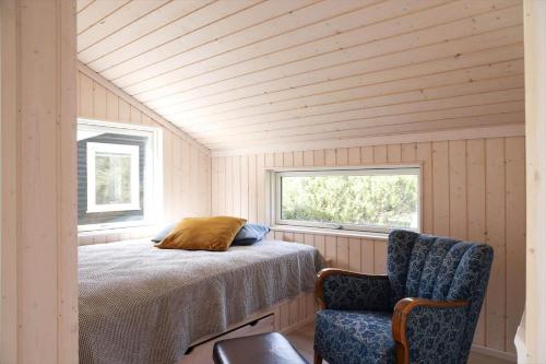 a bedroom with a bed and a chair and a window at 11120-1-Nykobing-Sj-Birkehaekken-9 in Nykøbing Sjælland