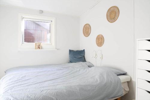 a white bedroom with a bed and a window at 12258-1-Sjaellands-Odde-Fasanvang-11 in Tjørneholm