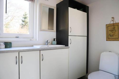 a white kitchen with a sink and a refrigerator at 13393-1-Vig-Lyngtoftevej-9-D in Vig