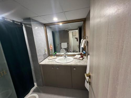 a bathroom with a sink and a mirror at Airport Hotel in Karachi
