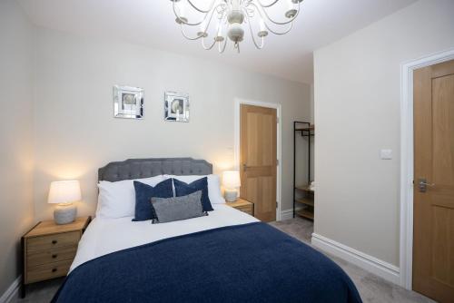 a bedroom with a large bed and a chandelier at Apartment 1, Elizabeth Hall in Ledbury