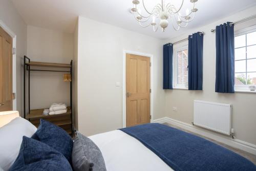 a bedroom with a bed and a chandelier at Apartment 1, Elizabeth Hall in Ledbury