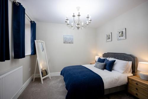 a bedroom with a bed and a chandelier at Apartment 1, Elizabeth Hall in Ledbury