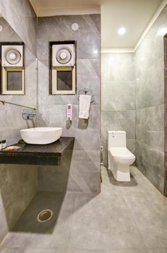 a bathroom with a sink and a toilet at Airport La Sapphire Hotel & Restaurant in New Delhi