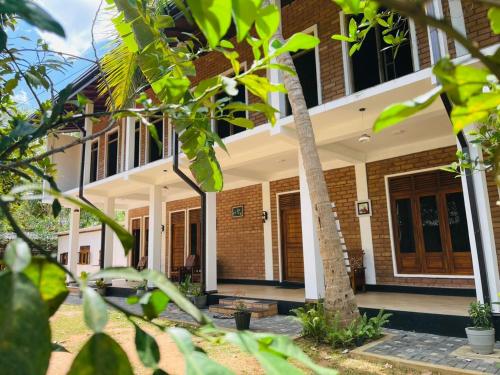 an image of a house with trees in the foreground at Sigiri Bawana in Sigiriya