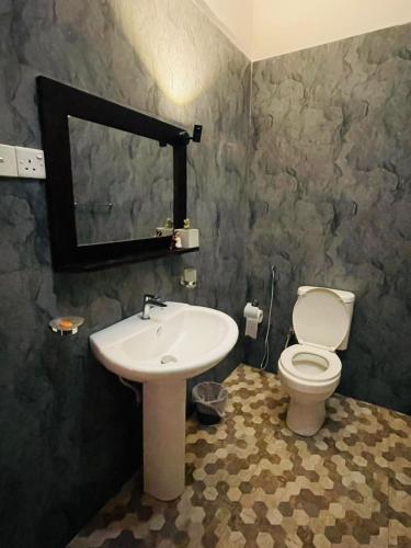 a bathroom with a sink and a toilet and a mirror at Sigiri Bawana in Sigiriya