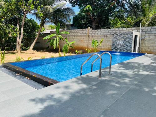 a swimming pool in a yard next to a wall at Sigiri Bawana in Sigiriya
