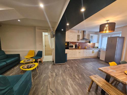 una sala de estar con un sofá y una mesa en chambre Carla gite le loft bleu, en Sablons