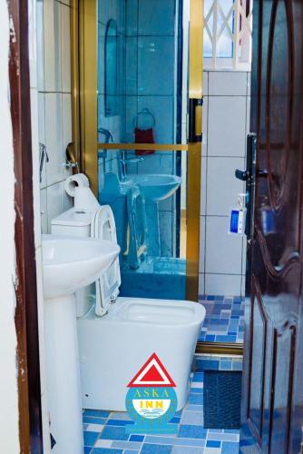 a bathroom with a toilet and a sink at Aska Inn Hotel in Yendi