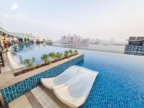 a tub sitting on the edge of a swimming pool at MarvelStay-Infinity Pool-Beachfront-The Palm in Dubai