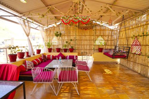 a large room with pink chairs and a table at Hotel The Surya Jaisalmer in Jaisalmer