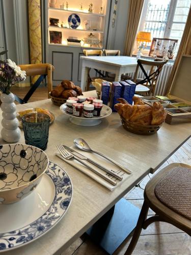 a table with plates of food and bread on it at Le Palais de la Cathédrale in Saint-Omer