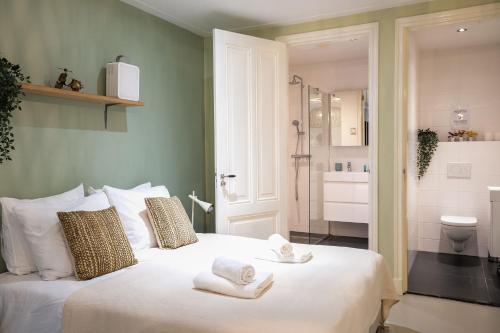 a bedroom with a white bed with towels on it at NEW! Modern Gallery Nassau Canal Suite in Amsterdam