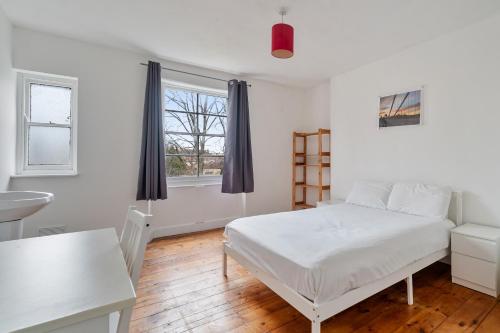 a bedroom with a bed and a sink and a window at Georgian Shared House No'64 - By Clifton Short Lets in Bristol