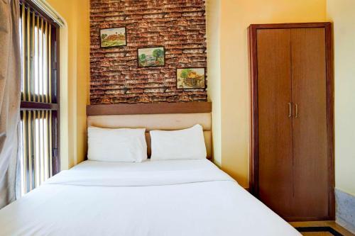 a bedroom with a bed and a brick wall at Townhouse Heritage Scindia Ghat in Varanasi
