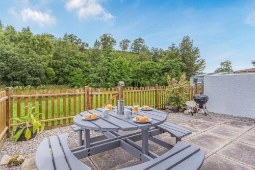 a blue picnic table and chairs on a patio at 2 Bed in Newtonmore oc-e32418 in Newtonmore