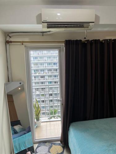 a bedroom with a window with a view of a building at MOA Staycation Condotel PASAY in Manila