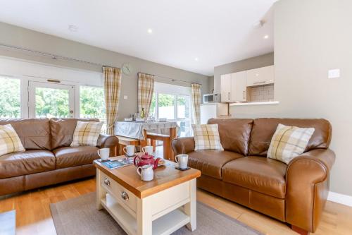 a living room with two brown leather couches and a table at 2 Bed in Newtonmore oc-e32418 in Newtonmore
