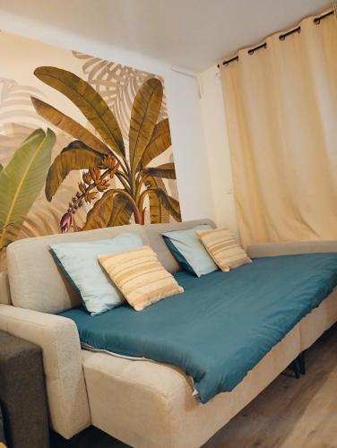 a bed with blue sheets and pillows in a room at centre ville confortable in Gourin