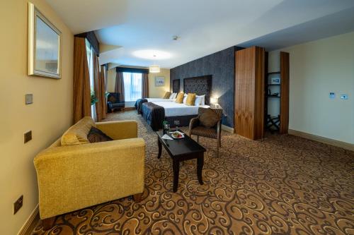 a hotel room with a bed and a couch at Kettles Country House Hotel in Swords