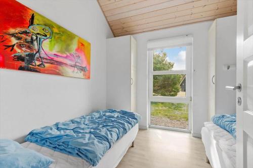 ein Schlafzimmer mit einem Bett und einem Gemälde an der Wand in der Unterkunft FAN011 Fanø - Bjerges Toft 8 in Fanø