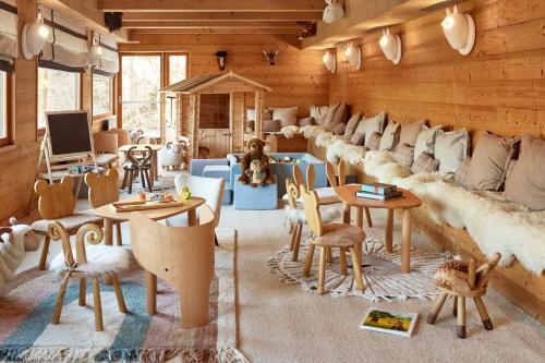 a living room with couches and tables and chairs at Hôtel L'Arboisie in Megève