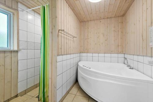 a white tub in a bathroom with a window at FAN049-Fano-Larses-Toft-31 in Fanø