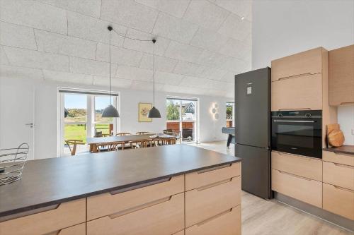 a kitchen with a black refrigerator and a dining room at FAN050-Fano-Skovsletten-2 in Fanø
