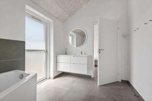 a white bathroom with a sink and a mirror at FAN050-Fano-Skovsletten-2 in Fanø