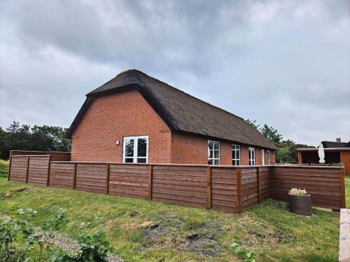 a red brick building with a fence in front of it at FAN050-Fano-Skovsletten-2 in Fanø