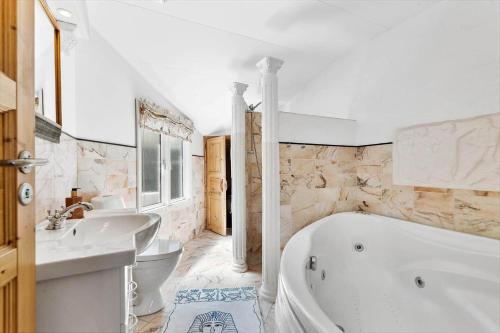 a white bathroom with a tub and a sink at FAN025-Fano-Ostre-Klitvej-17 in Fanø