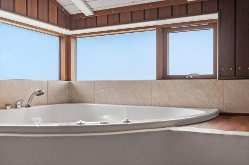 a large bath tub in a room with two windows at FAN022-Fano-Hympelvej-17 in Fanø