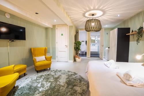 a room with a bed and a chair and a tv at NEW! Modern Gallery Nassau Canal Suite in Amsterdam