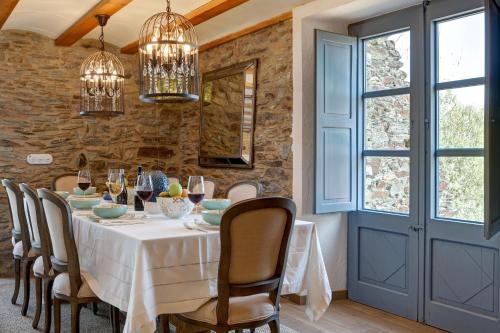 a dining room with a white table and chairs at Can Font de Muntanya in Cruïlles