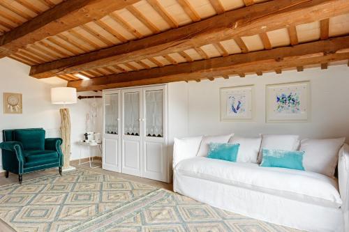 a living room with a white couch and a green chair at Can Font de Muntanya in Cruïlles