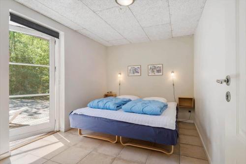 Un dormitorio con una cama con almohadas azules. en FAN040-Fano-Nymarken-1, en Fanø