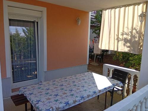 a porch with a table and a window at ANKARAN SOBE MARA in Ankaran