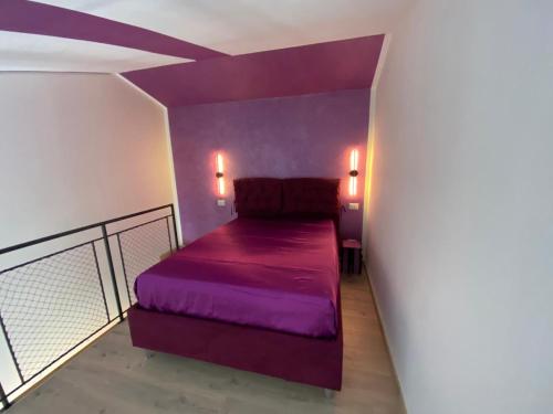 a bedroom with a purple bed in a room at Dimora Filippo in SantʼElpidio a Mare