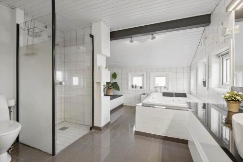 a white bathroom with a tub and a sink at FAN056-Fano-Vesterengen-6 in Fanø