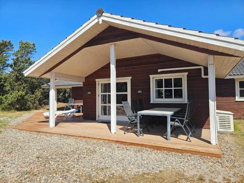 a cabin with a table and chairs on a deck at FAN057-Fano-Sonder-Nytoft-4 in Fanø