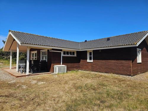 a house with a black roof and a yard at FAN057-Fano-Sonder-Nytoft-4 in Fanø