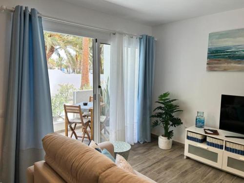 a living room with a couch and a sliding glass door at Casa Pura Vida in Tarajalejo