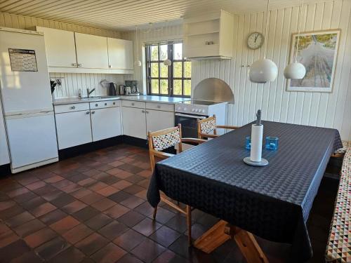 a kitchen with a table and a kitchen with white cabinets at FAN068-Fano-Dalen-10 in Fanø