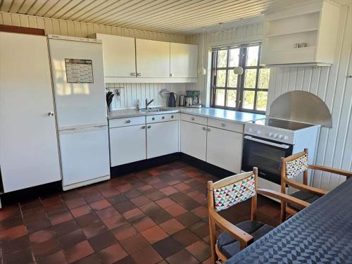 a kitchen with white appliances and a table and chairs at FAN068-Fano-Dalen-10 in Fanø