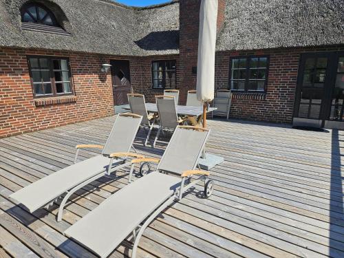 a group of lounge chairs on a wooden deck at FAN068-Fano-Dalen-10 in Fanø