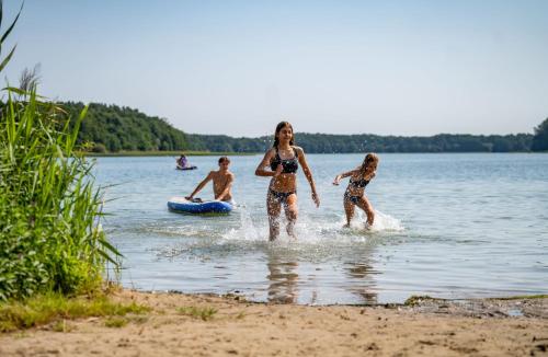 a group of people in the water on a beach at AHORN Seehotel Templin in Templin