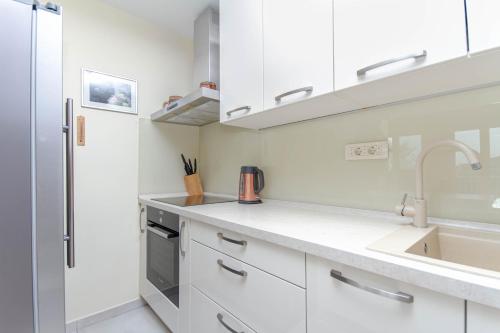 een keuken met witte kasten en een spoelbak bij Suprema Vista in Split