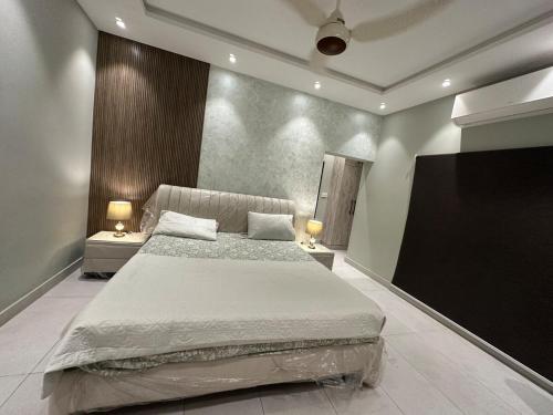 a bedroom with a large bed and a flat screen tv at 2BR Modern Home in the heart of lahore New gardentown in Lahore