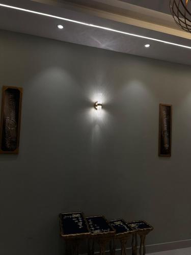a wall with three tables on it with a clock on it at 2BR Modern Home in the heart of lahore New gardentown in Lahore