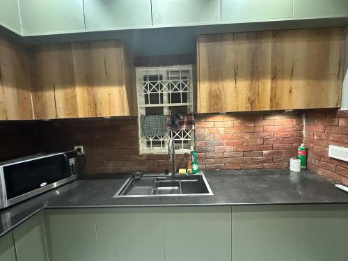 a kitchen with a sink and a microwave at 2BR Modern Home in the heart of lahore New gardentown in Lahore